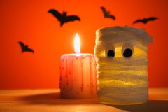 Концепция на хеллоуин Летучие мыши и мумия от опарника, повязк и свечей на оранжевой предпосылке Стоковые Фото Концепция на хеллоуин Летучие мыши и мумия от опарника, повязк и свечей на оранжевой предпосылке Стоковые Фото