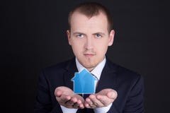 Концепция недвижимости - молодой человек держа небольшой дом в его руках стоковая фотография rf Концепция недвижимости - молодой человек держа небольшой дом в его руках стоковая фотография rf