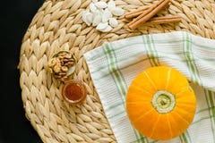 Концепция осени Небольшие тыква, семена, мед, грецкие орехи и ручки циннамона на салфетке круга гиацинта воды дальше стоковое фото rf Концепция осени Небольшие тыква, семена, мед, грецкие орехи и ручки циннамона на салфетке круга гиацинта воды дальше стоковое фото rf