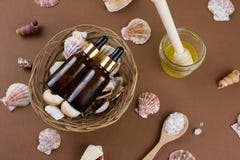 Косметическая бутылка масла на коричневой предпосылке с картиной раковин стоковые изображения Косметическая бутылка масла на коричневой предпосылке с картиной раковин стоковые изображения