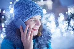 Косой портрет красивой молодой женщины носит модную шляпу зимы и куртка имеет телефонный разговор внешний, представляет против c стоковые изображения Косой портрет красивой молодой женщины носит модную шляпу зимы и куртка имеет телефонный разговор внешний, представляет против c стоковые изображения