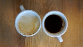 Кофе Americano в 2 чашках с деревянной предпосылкой стоковое фото rf Кофе Americano в 2 чашках с деревянной предпосылкой стоковое фото rf