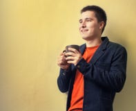 Кофе молодого бизнесмена выпивая около стены Стоковые Изображения RF Кофе молодого бизнесмена выпивая около стены Стоковые Изображения RF