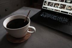 Кофе на конкретной таблице с ноутбуком как фон стоковая фотография Кофе на конкретной таблице с ноутбуком как фон стоковая фотография