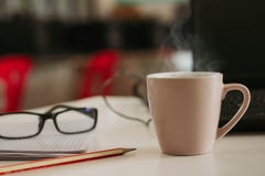 Кофейная чашка с ручкой циннамона на деревянной таблице стоковое изображение Кофейная чашка с ручкой циннамона на деревянной таблице стоковое изображение