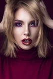 Красивая белокурая женщина в красном свитере с ярким составом и темными губами Сторона красотки стоковые фото Красивая белокурая женщина в красном свитере с ярким составом и темными губами Сторона красотки стоковые фото