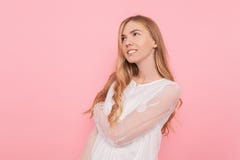 Красивая внимательная девушка в белом платье, мечты что-то, делая планы, на розовой предпосылке стоковые изображения rf Красивая внимательная девушка в белом платье, мечты что-то, делая планы, на розовой предпосылке стоковые изображения rf