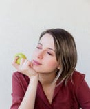 Красивая грустная девушка с яблоком в красной куртке o стоковое изображение rf Красивая грустная девушка с яблоком в красной куртке o стоковое изображение rf