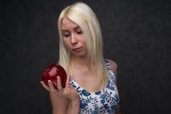 Красивая девушка в модном платье с яблоком стоковые изображения Красивая девушка в модном платье с яблоком стоковые изображения
