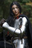Красивая девушка ратника с chainmail шпаги нося и панцырь в загадочном лесе стоковое изображение Красивая девушка ратника с chainmail шпаги нося и панцырь в загадочном лесе стоковое изображение