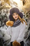 Красивая женщина в белом пуловере с размером с сверх крышкой меха наслаждаясь пейзажем зимы в девушке леса белокурой представляя стоковое фото Красивая женщина в белом пуловере с размером с сверх крышкой меха наслаждаясь пейзажем зимы в девушке леса белокурой представляя стоковое фото