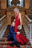Красивая женщина в красном платье стоит с человеком, женихом и невеста, счастливыми новобрачными стоковое изображение rf Красивая женщина в красном платье стоит с человеком, женихом и невеста, счастливыми новобрачными стоковое изображение rf