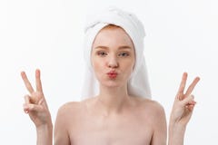 Красивая кавказская женщина прикладывая маску на ее стороне с 2 пальцами подписывает белую предпосылку стоковое изображение Красивая кавказская женщина прикладывая маску на ее стороне с 2 пальцами подписывает белую предпосылку стоковое изображение