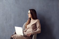Красивая коммерсантка с длинными волосами используя современный портативный компьютер пока сидящ в его современном офисе просторн стоковые изображения rf Красивая коммерсантка с длинными волосами используя современный портативный компьютер пока сидящ в его современном офисе просторн стоковые изображения rf