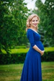 Красивая молодая беременная женщина в голубом платье стоковое фото rf Красивая молодая беременная женщина в голубом платье стоковое фото rf