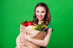 Красивая молодая женщина держа продуктовую сумку полный стоковые изображения Красивая молодая женщина держа продуктовую сумку полный стоковые изображения