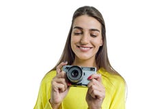 Красивая молодая женщина в желтом свитере держа винтажную камеру в ее руках, усмехающся, фотографирующ, смотря с Whit интереса стоковое фото rf Красивая молодая женщина в желтом свитере держа винтажную камеру в ее руках, усмехающся, фотографирующ, смотря с Whit интереса стоковое фото rf