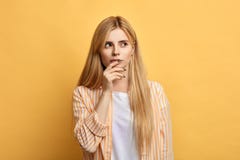Красивая молодая женщина с пальцами на ее губах выражает смущенную эмоцию стоковые фото Красивая молодая женщина с пальцами на ее губах выражает смущенную эмоцию стоковые фото