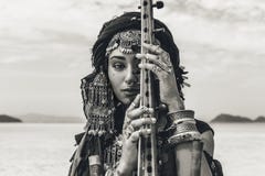 Красивая молодая стильная племенная женщина в восточном костюме играя ситар outdoors конец вверх стоковые изображения rf Красивая молодая стильная племенная женщина в восточном костюме играя ситар outdoors конец вверх стоковые изображения rf