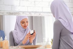 Красивая мусульманская девушка с проблемой угорь используя сливк стоковое фото rf Красивая мусульманская девушка с проблемой угорь используя сливк стоковое фото rf