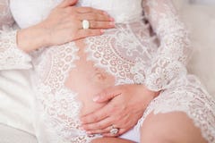 Красивая мягкая и чувственная беременная девушка в белом прозрачном openwork платье лежа на софе стоковые изображения rf Красивая мягкая и чувственная беременная девушка в белом прозрачном openwork платье лежа на софе стоковые изображения rf