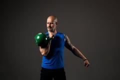 Красивая тренировка спортсмена с kettlebell, предпосылкой студии стоковое изображение rf Красивая тренировка спортсмена с kettlebell, предпосылкой студии стоковое изображение rf