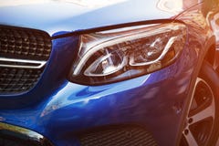 Красивая фара голубого автомобиля концом-вверх в солнечном дне Вид с к стороной стоковые изображения rf Красивая фара голубого автомобиля концом-вверх в солнечном дне Вид с к стороной стоковые изображения rf