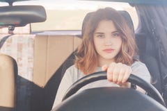Красивой женщина убежденная собственной личностью в приводах перехода автомобиле, был внимательна на дороге, сидит за колесом, им стоковое изображение rf Красивой женщина убежденная собственной личностью в приводах перехода автомобиле, был внимательна на дороге, сидит за колесом, им стоковое изображение rf