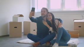 Красивые кавказские пары делая selfies используя смартфон пока сидящ на поле около коробок коробки акции видеоматериалы Красивые кавказские пары делая selfies используя смартфон пока сидящ на поле около коробок коробки акции видеоматериалы
