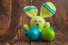 Красивые красочные пасхальные яйца и игрушка зайчика Концепция пасхи на деревянной предпосылке стоковые изображения rf Красивые красочные пасхальные яйца и игрушка зайчика Концепция пасхи на деревянной предпосылке стоковые изображения rf
