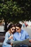 Красивые туристские пары путешествуя используя карту и телефон Портрет усмехаясь человека и молодой женщины стоя на улице, ища De стоковое фото Красивые туристские пары путешествуя используя карту и телефон Портрет усмехаясь человека и молодой женщины стоя на улице, ища De стоковое фото
