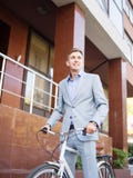 Красивый бизнесмен ехать велосипед на городской предпосылке уклад жизни принципиальной схемы здоровый скопируйте космос стоковое изображение rf Красивый бизнесмен ехать велосипед на городской предпосылке уклад жизни принципиальной схемы здоровый скопируйте космос стоковое изображение rf