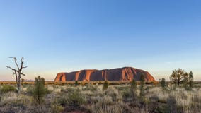 Красивый вид Uluru на зоре с горами Olgas на заднем плане, Австралия стоковые фото Красивый вид Uluru на зоре с горами Olgas на заднем плане, Австралия стоковые фото