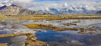 Красивый вид естественного плато с болотом, отражение потока и воды яркой предпосылки неба дня Сценарное отключение к Тибету стоковая фотография Красивый вид естественного плато с болотом, отражение потока и воды яркой предпосылки неба дня Сценарное отключение к Тибету стоковая фотография