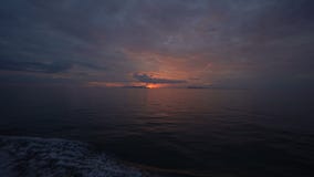 Красивый заход солнца на развевая море, взгляд от верхней палубы moving крейсера шлюпки Красивый заход солнца на развевая море, взгляд от верхней палубы moving крейсера шлюпки
