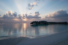 Красивый заход солнца на пляже обозревая бунгало воды в Мальдивах стоковая фотография rf Красивый заход солнца на пляже обозревая бунгало воды в Мальдивах стоковая фотография rf