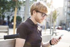 Красивый кавказский человек битника используя сидеть мобильного телефона внешний в парке День солнечности лета Концепция молодых стоковые фотографии rf Красивый кавказский человек битника используя сидеть мобильного телефона внешний в парке День солнечности лета Концепция молодых стоковые фотографии rf