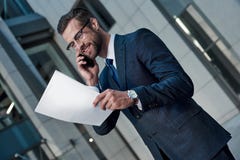 Красивый контракт чтения костюма молодого человека полностью пока стоящ стоковое изображение rf Красивый контракт чтения костюма молодого человека полностью пока стоящ стоковое изображение rf