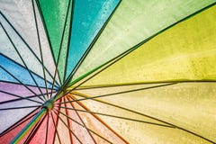 Красивый красочный влажный зонтик с просвечивающим солнцем увиденным снизу стоковая фотография Красивый красочный влажный зонтик с просвечивающим солнцем увиденным снизу стоковая фотография