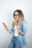 Красивый молодой белокурый смартфон удерживания женщины выглядит счастливым концом вверх по белой предпосылке стоковое изображение Красивый молодой белокурый смартфон удерживания женщины выглядит счастливым концом вверх по белой предпосылке стоковое изображение