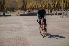 Красивый молодой человек сидя на велосипеде и smilling в городе стоковое фото Красивый молодой человек сидя на велосипеде и smilling в городе стоковое фото