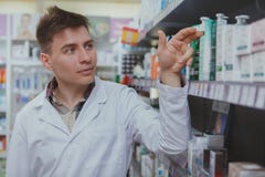 Красивый мужской аптекарь работая на его аптеке стоковое изображение Красивый мужской аптекарь работая на его аптеке стоковое изображение