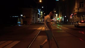 Красивый подходящий бородатый человек в striped поло и зеленые шорты пересекают дорогу вечером на crosswalk сток-видео Красивый подходящий бородатый человек в striped поло и зеленые шорты пересекают дорогу вечером на crosswalk сток-видео