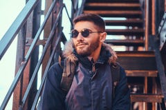 Красивый стильный молодой человек сидя на лестницах снаружи стоковые фото Красивый стильный молодой человек сидя на лестницах снаружи стоковые фото