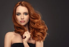 Красная с волосами женщина с объемистым, сияющим и курчавым стилем причёсок Frizzy волосы Красная с волосами женщина с объемистым, сияющим и курчавым стилем причёсок Frizzy волосы