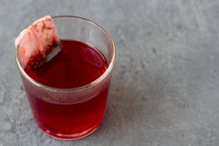 Красное karkade гибискуса, подняло пакетик чая в стекле стоковые изображения rf Красное karkade гибискуса, подняло пакетик чая в стекле стоковые изображения rf