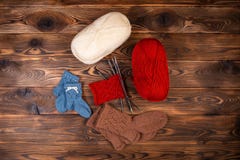Красные и белые покрашенные шарики потока, вязать игл и связанных носков на деревянной предпосылке стоковые изображения Красные и белые покрашенные шарики потока, вязать игл и связанных носков на деревянной предпосылке стоковые изображения