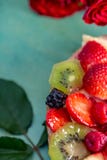 Красные розы цветков и красивый очень вкусный сладкий торт с ягодами на зеленой предпосылке стоковые изображения Красные розы цветков и красивый очень вкусный сладкий торт с ягодами на зеленой предпосылке стоковые изображения