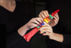 Красочная труба и 4 руки женщины принимая его стоковые фото Красочная труба и 4 руки женщины принимая его стоковые фото