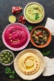 Красочные разнообразные hummus, caponata, оливки, пита и гранатовое дерево на темной деревенской предпосылке Взгляд сверху, плоск стоковое фото Красочные разнообразные hummus, caponata, оливки, пита и гранатовое дерево на темной деревенской предпосылке Взгляд сверху, плоск стоковое фото